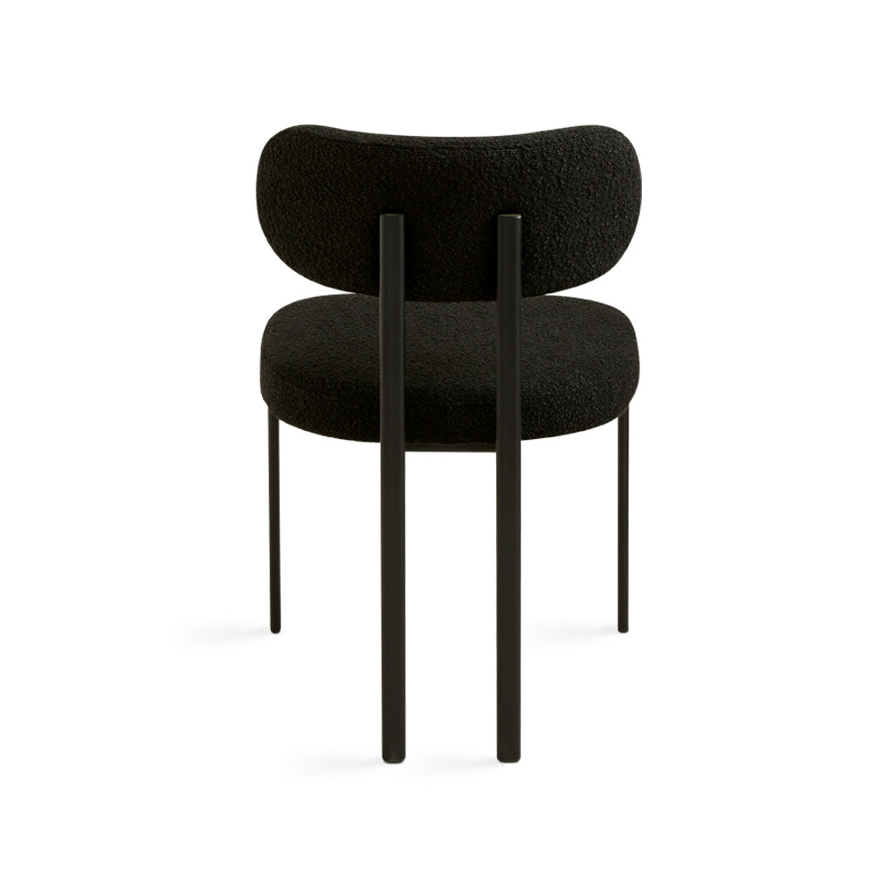 Black Boucle Otis dining chair by Xcella featuring a sleek, modern design with a cushioned seat and wooden legs.