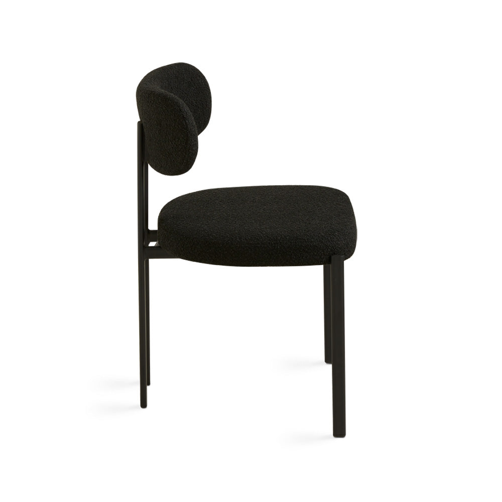 Black Boucle Otis Dining Chair by Xcella with sleek modern design and wooden legs, shown from a side angle.
