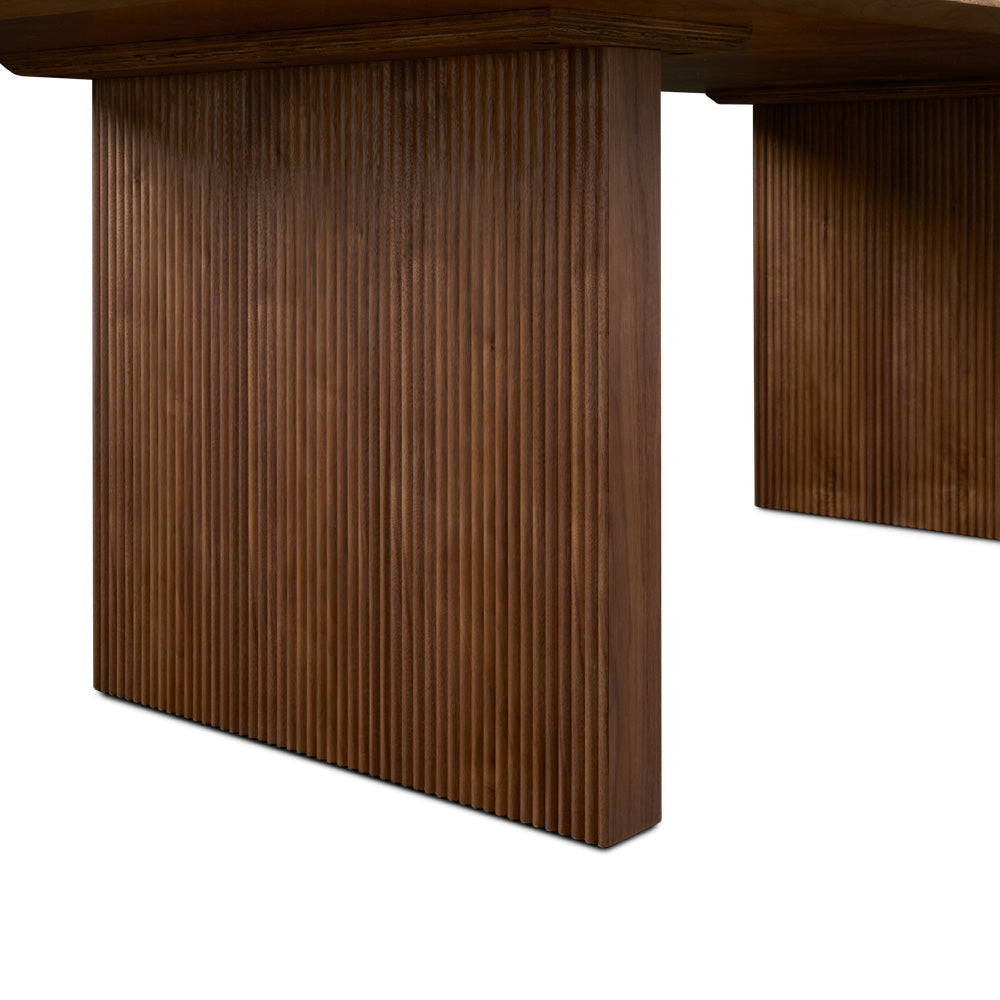 Xcella Pauline dining table with a sleek wooden surface and modern design, shown as a floor model in a dining room setting.