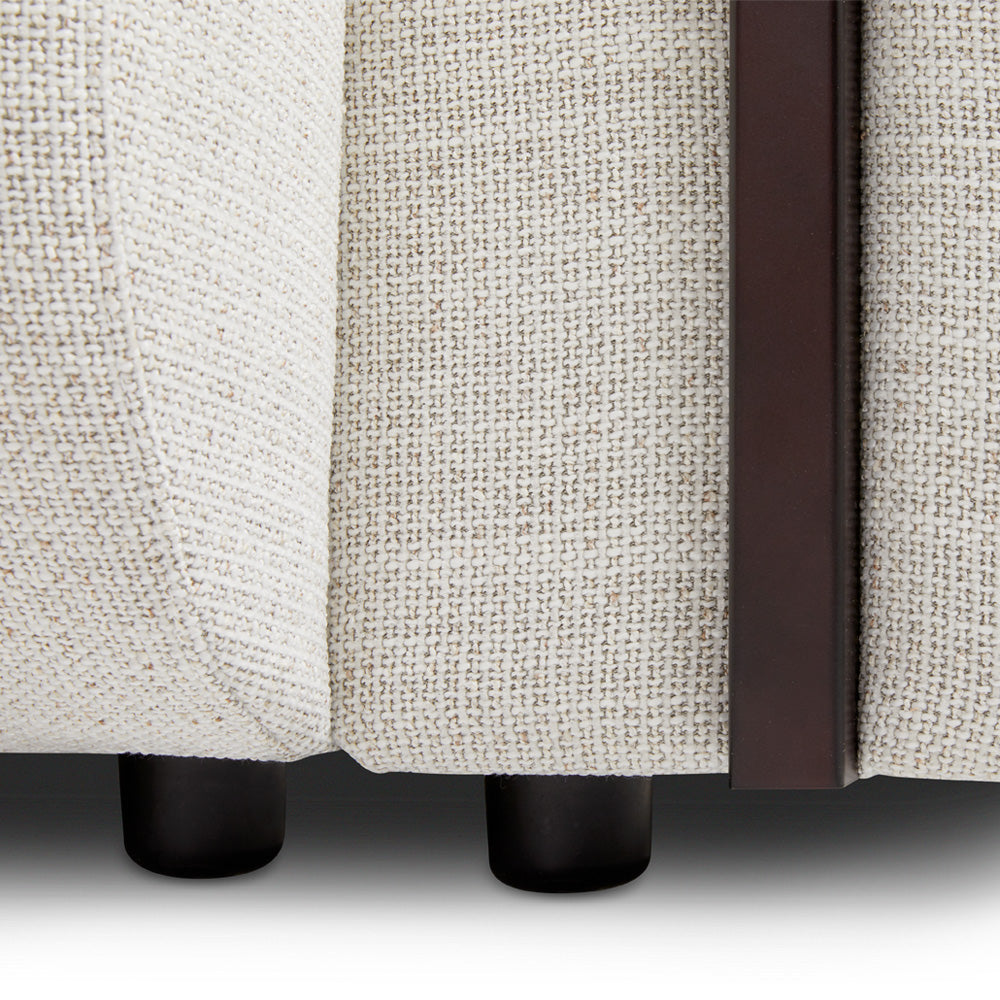 Xcella Designers Collection Brenton 4-seater sofa with plush fabric, wooden legs, and modern design, shown from a front angle.
