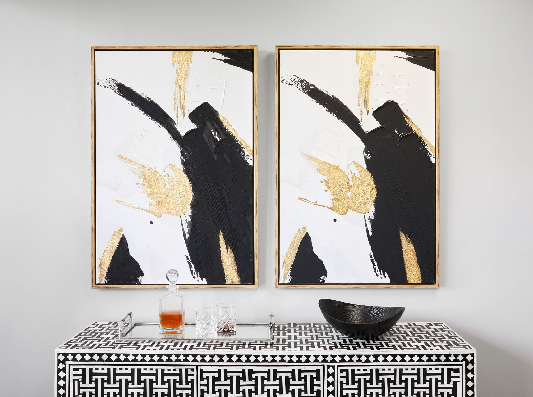 Black and gold wall art by Xcella featuring abstract geometric designs on a white background.